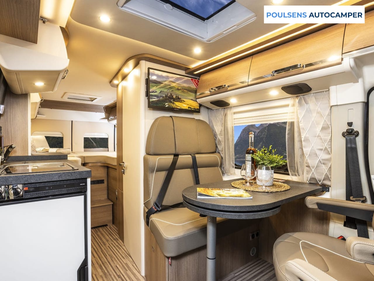 Salon intérieur du camping-car urbain Carthago Van 640 2023 d’occasion avec banquettes, éclairage LED et table centrale.