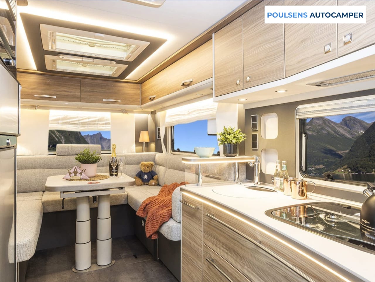 Salon intérieur du camping-car intégré Dethleffs ALPA I 6820-2 2025 avec banquettes confortables et table centrale