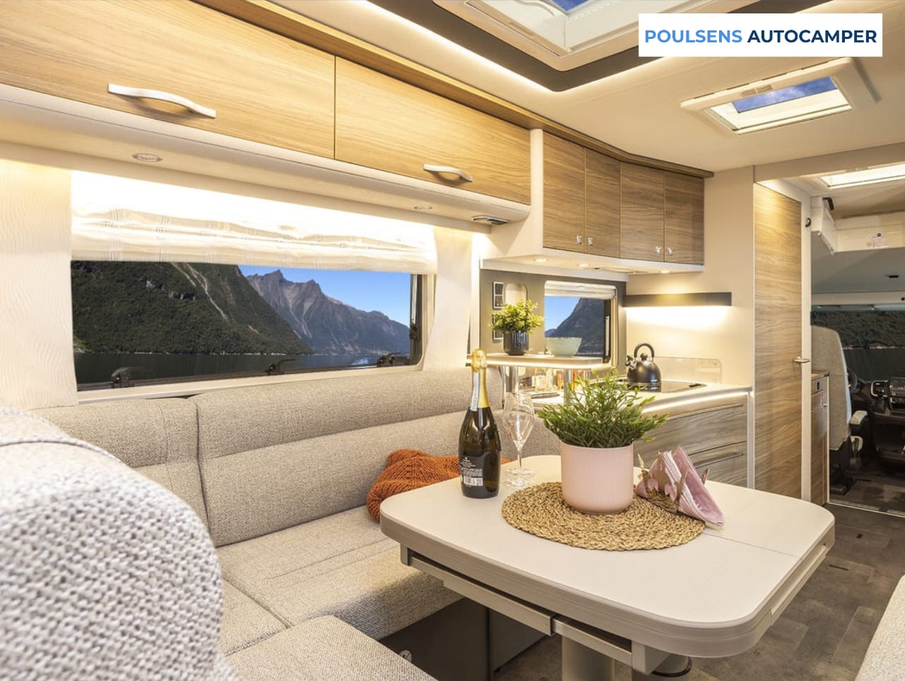 Salon intérieur du camping-car intégré Dethleffs ALPA I 6820-2 2025 avec banquettes confortables et table centrale