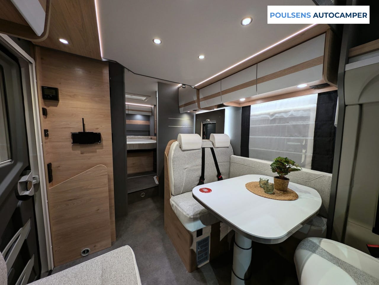 Salon en L du camping-car semi-intégré Dethleffs Just Camp T 7052 2026 avec banquettes confortables et table autoportante