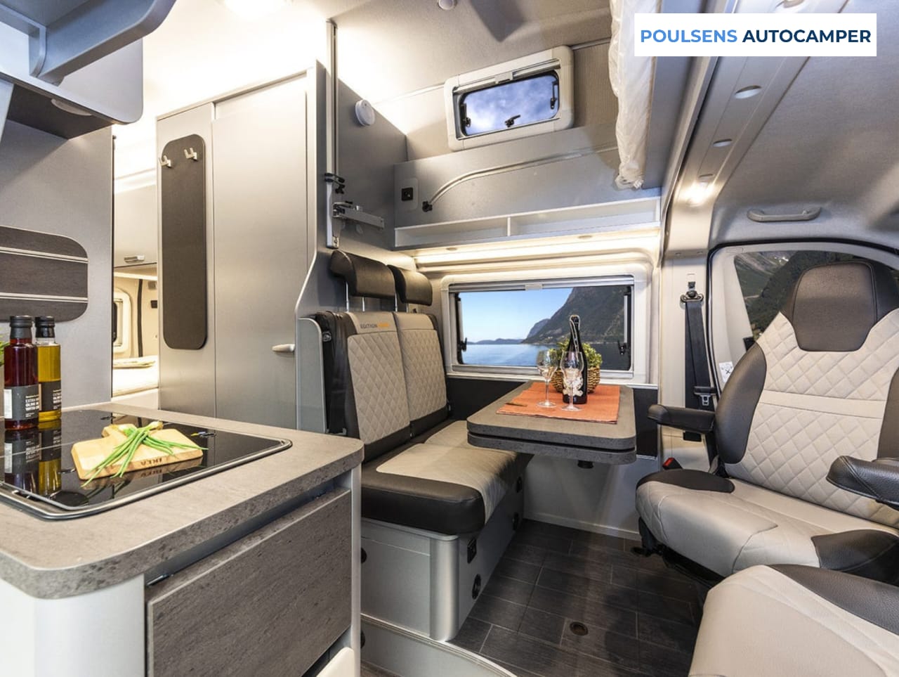 Vue intérieure du camping-car semi-intégré Weinsberg CARASUITE 700 DX 2026 avec banquettes, éclairage LED et plan de travail extensible de la cuisine
